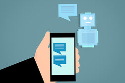 Grafik zeigt eine Hand mit Smartphone, auf dessen Bildschirm Sprechblasen abgebildet sind. Daneben ein kleiner Roboter mit einer Sprechblase.